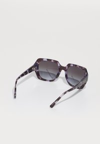 Ochelari de soare hexagonali cu un cadru din acetat cu un model purpuriu, lentile gri închis cu un gradient și accente metalice pe brațe.