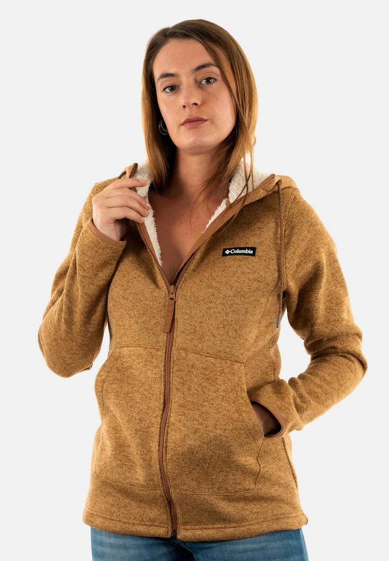 Sudadera con cremallera marrón hecha de un tejido texturizado, que cuenta con una capucha forrada de forro polar, bolsillos laterales y un logo en el lado izquierdo del pecho.