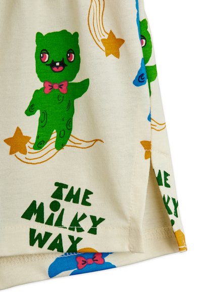 Λευκό ύφασμα με πράσινο καρτούν αρκουδάκι που φορά ροζ παπιγιόν, κίτρινα αστέρια και κείμενο που λέει «THE MILKY WAY».