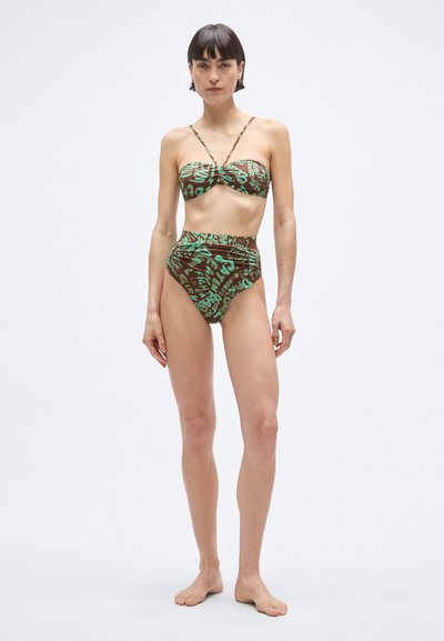 Bikini szett barna alapon zöld grafikus mintákkal. A felső bandeau stílusú, vékony pántokkal; az alsó magas derekú szabású.