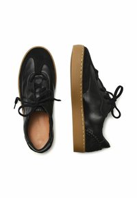 Musta nahka- ja mokkanahkakengät, joissa on pyöreä kärki, nauhakiinnitys ja kumipohja, jossa on koristeommellut yksityiskohdat.