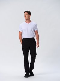 Schwarze Cargo-Hosen mit mehreren Taschen, kombiniert mit einem schmal geschnittenen weißen V-Ausschnitt-T-Shirt. Modell trägt schwarze Sneakers vor einem neutralen Hintergrund.