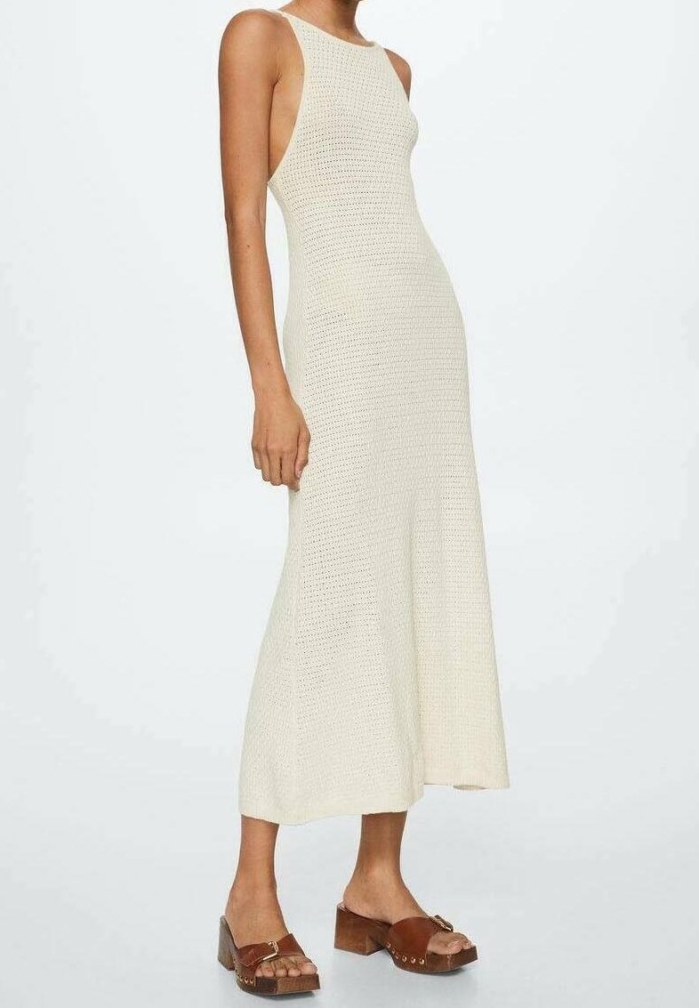 Robe maxi en tricot couleur blanc cassé avec un corsage ajusté et un ourlet évasé. Dispose de larges bretelles et de côtés ouverts. Sandales à plateforme marron incluses.