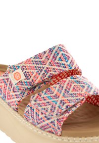 Infradito intrecciati con un motivo geometrico multicolore, caratterizzati da due cinturini e una suola color terra con dettagli di cucitura bianca.