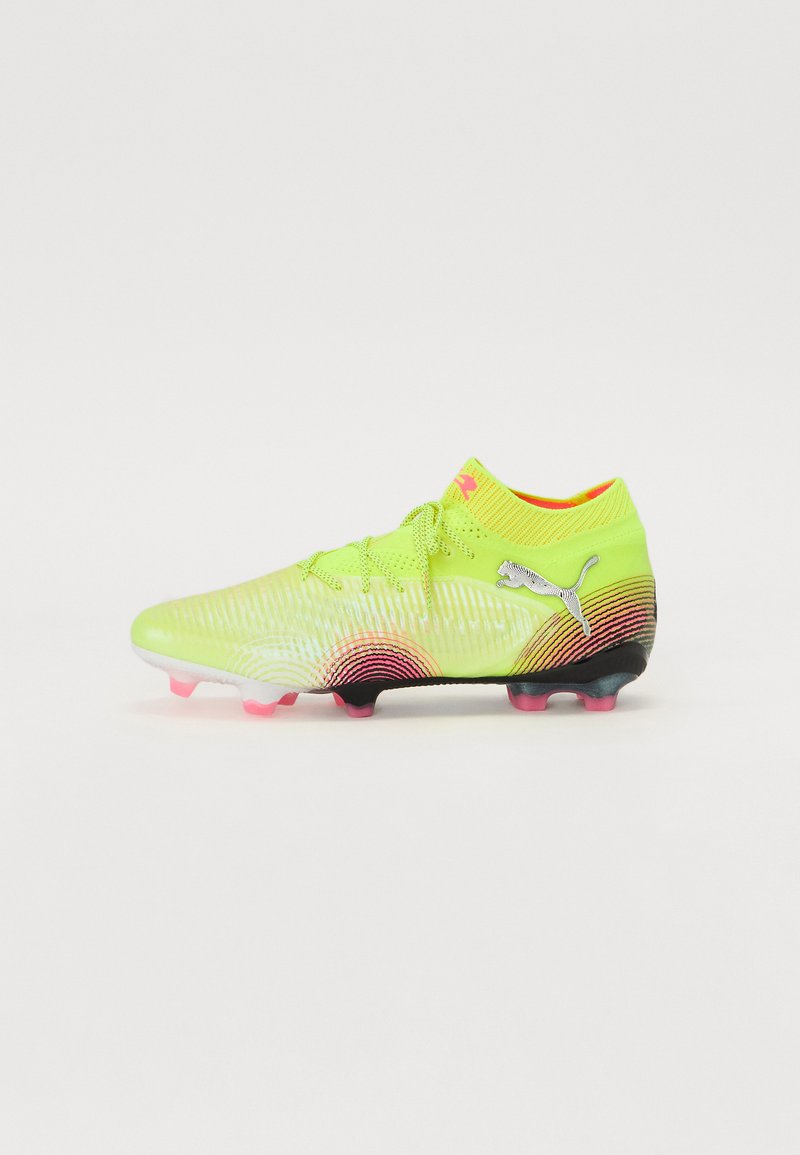Botas de fútbol amarillas brillantes con una parte superior texturizada, acentos en degradé rosa y negro, y un diseño de collar flexible. Presenta un cordaje elegante y un logo.
