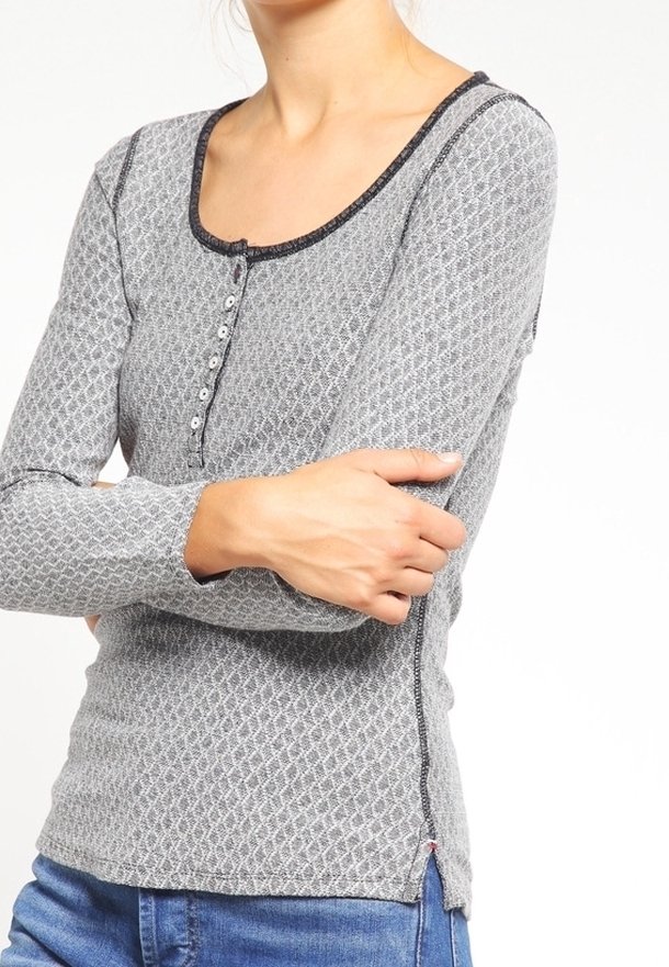 Long-sleeve shirt in gray with a diamond pattern, scoop neck, button closure, and black trim along the neckline and cuffs.