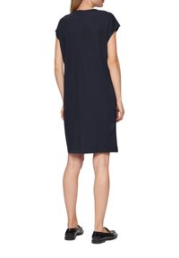 Navyblaues Kleid aus weichem Stoff mit kurzen Ärmeln, knielangem Schnitt und seitlichen Schlitzen für mehr Bewegungsfreiheit. Einfaches, minimalistisches Design.