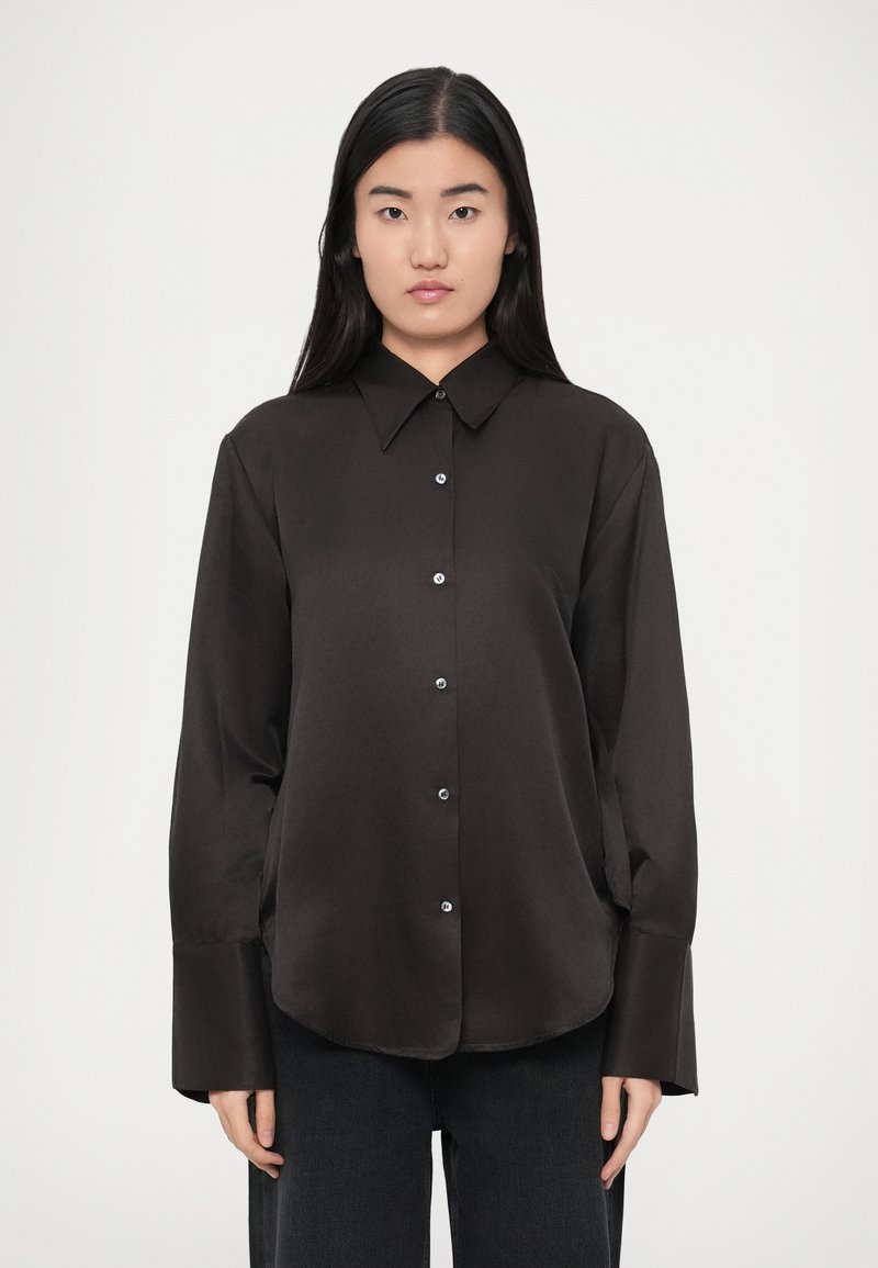 Czarna koszula z długim rękawem wykonana z gładkiej tkaniny, z zapinanym na guziki przodem, klasycznym kołnierzem i szerokimi mankietami, posiadająca zaokrąglony dół.