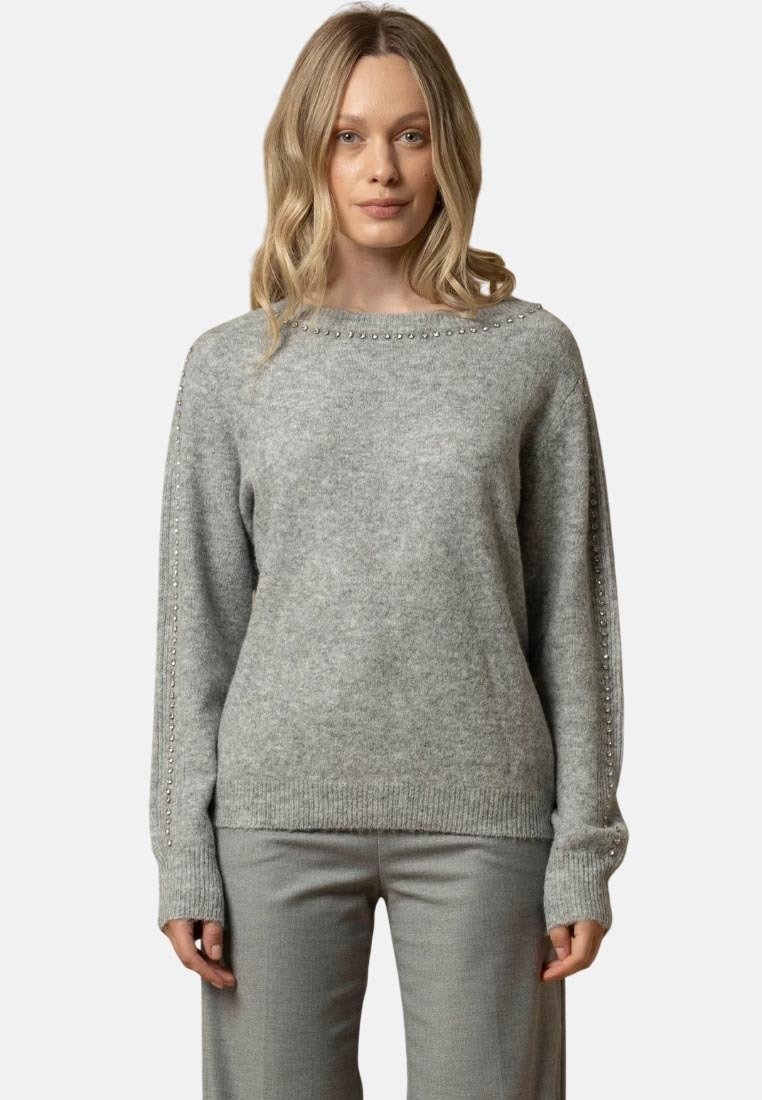 Maglione grigio lavorato a maglia con scollatura rotonda, decorato con borchie argentate lungo le maniche. Tessuto morbido e vestibilità rilassata.