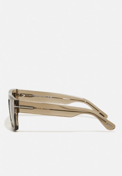 Ochelari de soare cu un cadru din plastic transparent maro, lentile rectangulare și părți subțiri cu un accent subtil de-a lungul templilor.