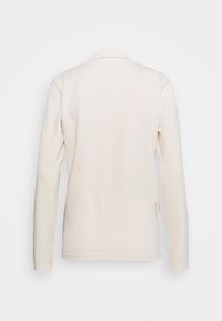 Bakifrån vy av en enkel, långärmad, off-white jacka med krage och rak nederkant mot en vit bakgrund.