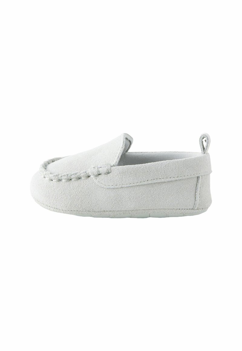 Chaussure bébé en daim gris clair doux à enfiler avec coutures visibles et languette sur le talon, vue de profil.