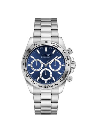Ασημένιο μεταλλικό ρολόι Guess χρονογράφος με μπλε καντράν, τρεις υποκαντράν, φωτεινούς δείκτες ώρας και μπρασελέ από ανοξείδωτο ατσάλι.