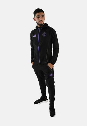 Chándal atlético negro con acentos morados, que incluye una chaqueta con cremallera y pantalones ajustados, fabricado en material ligero. Logotipo de Adidas visible.