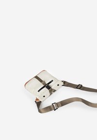 Witte crossbodytas met een bruine leren afwerking, verstelbare bruine riemen, een ritsvak aan de voorkant en een centrale gesp als sluiting. Gladde textuur.