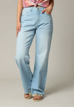 Jean large en denim bleu clair à taille haute, doté d'un design classique à cinq poches et d'une décoloration subtile pour une texture raffinée.