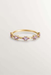 Anillo de tono dorado con cinco engastes ornamentales que presentan piedras preciosas de color púrpura claro, rodeadas de pequeños acentos rosas, mostrando un diseño delicado.