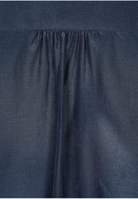 Tessuto blu navy con una texture liscia e leggermente lucida. Presenta cuciture arricciate nella parte superiore, creando un effetto drappeggiato al centro.