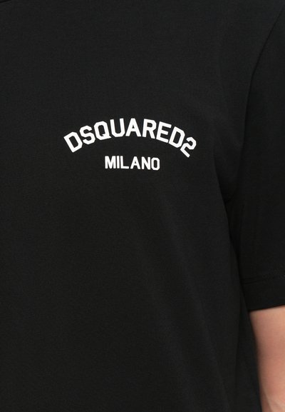 T-shirt nera in cotone con maniche corte. Testo bianco curvo "DSQUARED2 MILANO" stampato sul petto. Texture liscia e vestibilità classica.