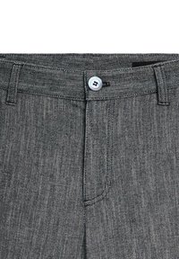 Pantalon gris avec un motif zigzag noir et blanc, fermeture à boutons, passants de ceinture et coutures noires visibles le long de la taille et de la braguette.