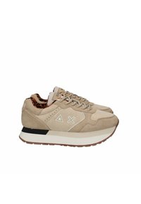 Beżowe zamszowe sneakersy z fakturowaną cholewką, białymi akcentami i brązową gumową podeszwą. Wnętrze wyściełane w panterkę oraz zdobione geometrycznymi wzorami.