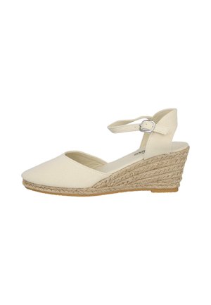 Sandalia beige de cuña con puntera cerrada, tira en el tobillo y hebilla plateada, con tacón trenzado de yute y suela de caucho.