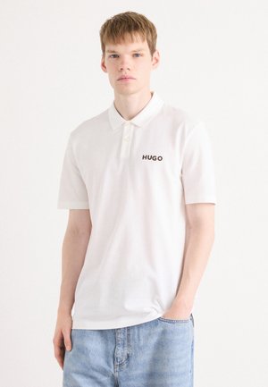 Hvid polo shirt med krave og tre knapper, prydet med et kontrastfyldt sort "HUGO" logo på venstre bryst. Fremstillet af bomuldsstof, kortærmet.