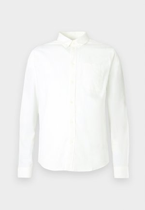 Biała koszula z długim rękawem na guziki, wykonana z bawełny, z ostro zakończonym kołnierzykiem i pojedynczą kieszenią po lewej stronie na piersi. Gładka tekstura.