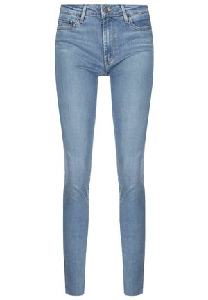 Jean skinny bleu clair avec poches avant, passants pour ceinture et fermeture par bouton, présenté sur fond blanc.