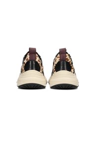 Un paio di sneakers viste da dietro, con suole beige, accenti neri testurizzati sul tallone e tessuto con stampa leopardata accompagnato da linguette color bordeaux.