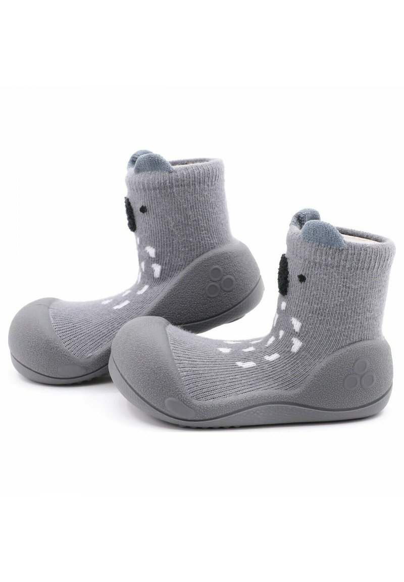 Calcetines de punto grises con suela de goma, que presentan una puntera redondeada y detalles de caras de animales divertidas, incluyendo orejas y ojos de botón negros.