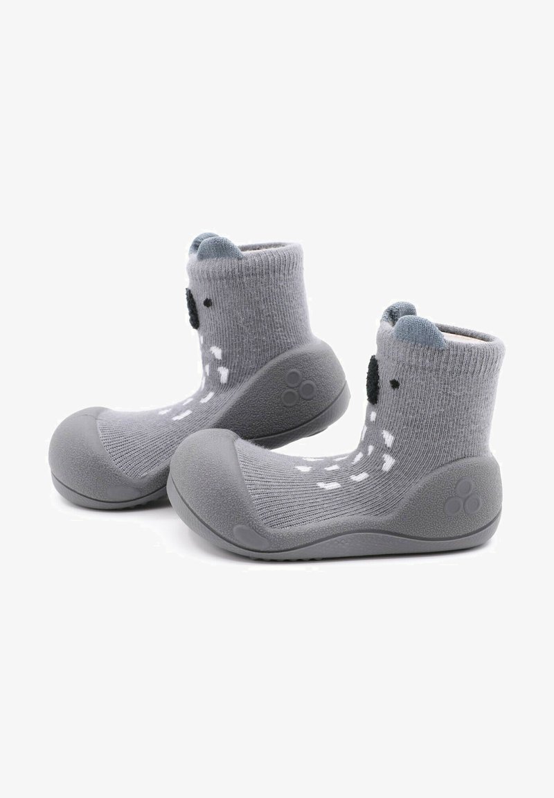 Calcetines de punto grises con suela de goma, que presentan una puntera redondeada y detalles de caras de animales divertidas, incluyendo orejas y ojos de botón negros.