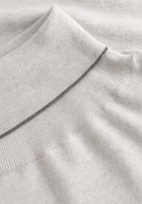 Hellgrauer Pullover mit einem gerippten Kragen und strukturiertem Stoff mit einem kontrastierenden Nahtdetail. Weiche, glatte Textur durchgehend.