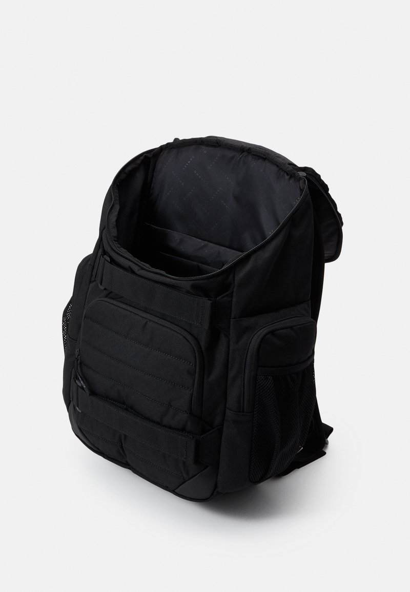 Zaino nero con apertura superiore con zip, tasche imbottite, tasca frontale con zip, tasche laterali in rete e spallacci regolabili. Tessuto testurizzato con design uniforme.