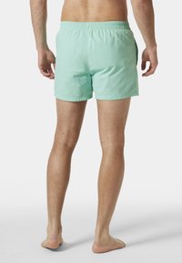 Pantaloni da bagno verde chiaro realizzati in tessuto leggero, con vita elastica e una vestibilità comoda, dalla texture liscia e di colore uniforme.