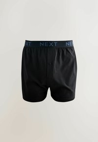 Čierne bavlnené boxerky s tmavomodrým elastickým pásom s logom „NEXT“. Predný detail s gombíkom, mäkká textúra a voľný strih.