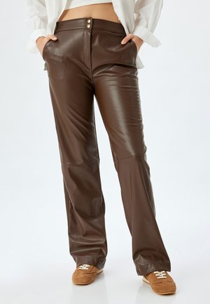Brown faux leather pants with a smooth texture, high waist, and two button closures. Features side pockets and a flared leg design.