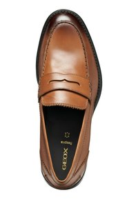 Mocassini in pelle marrone con un design cucito e una fascia rialzata. Presentano suola nera e marchio dorato all'interno. Texture liscia.