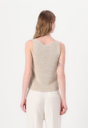 Lichtbeige geribbelde mouwloze top met een V-vormige halslijn en subtiele textuur, van achteren bekeken. Gecombineerd met lichtgekleurde broek.