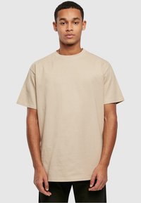 Beige katoenen t-shirt met een klassieke ronde hals, korte mouwen en een relaxed fit, zonder patronen of extra versieringen.