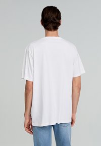Witte katoenen t-shirt met korte mouwen, een relaxed fit en een rechte zoom. De achterkant toont geen logo's of extra details.