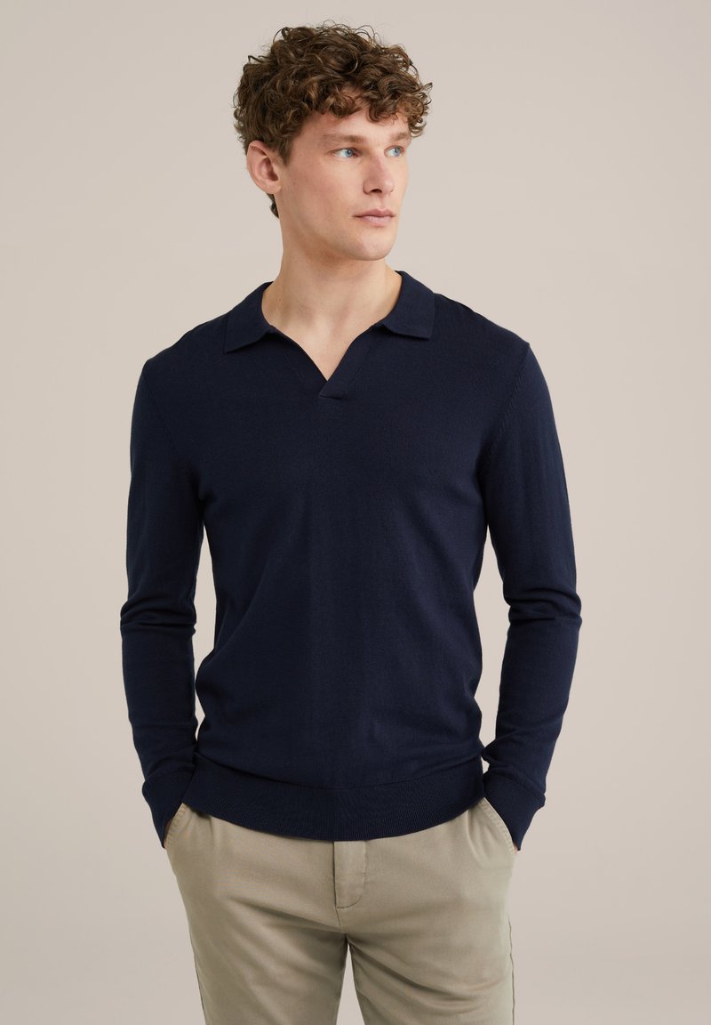 Pulover polo cu mânecă lungă de culoare bleu marin, cu un design în formă de V, realizat dintr-un material moale. Croială slim fit, cu manșete și tiv cu dantelă. Detalii de cusătură curate.
