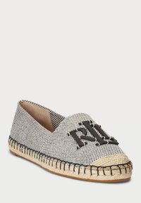 Textil sko med slip-on-design som har ett svart och vitt hundtandmönster, en rep-sula och en svart logotypdetalj på den övre framdelen.