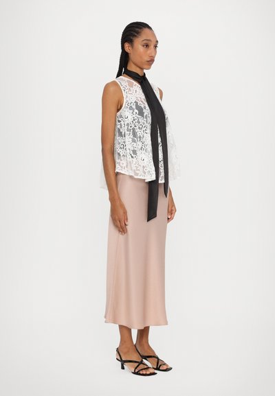 Lace white sleeveless top with a black neck tie paired with a blush pink midi skirt and black strappy heels. Smooth texture, elegant silhouette.