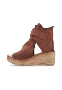 Brune læder wedge sandaler med en åben front og justerbar velcro-rem. Tekstureret overdel og lagdelt platform, der ligner træ.