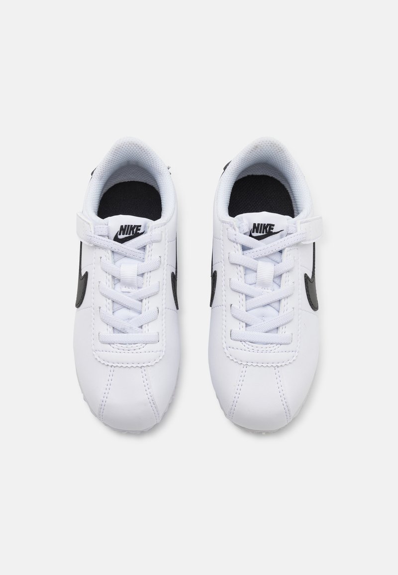 Zapatillas Nike blancas con acentos negros, que cuentan con un diseño de cordones, un cuello acolchado y una suela de goma texturizada. Forma simple y aerodinámica.