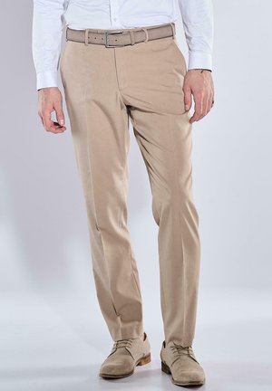 Beige chino pants with a flat front design, belt loops, and a slim fit, paired with light-colored suede shoes. Smooth fabric texture.