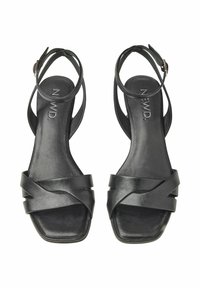Schwarze Ledersandalen mit einem quadratischen Zehendesign, schmalen Riemen mit einem Überkreuzmuster und einem verstellbaren Knöchelriemen.
