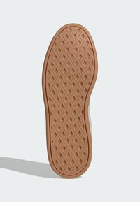 Gumowa podeszwa buta z diamentowym wzorem. Okrągły obcas i teksturowana powierzchnia w jasnobrązowym kolorze, wskazujące na przyczepność i trwałość.