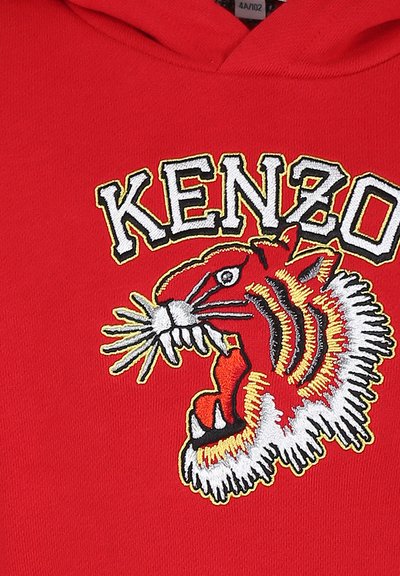 Haut à capuche rouge avec un design de tigre brodé, des accents blancs et noirs, et le mot "KENZO" en lettres noires en gras et contourées.